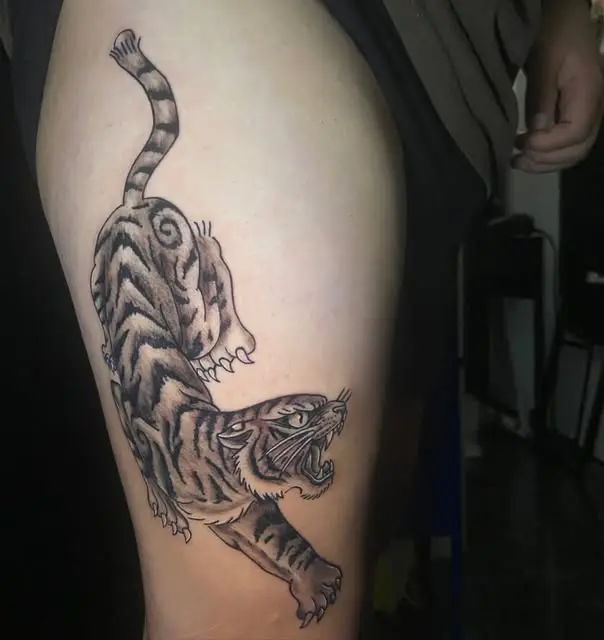 Tigre tradicional con fondo de blackwork en el muslo